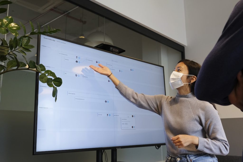 A woman demonstrating to his co-worker, the RFP process.